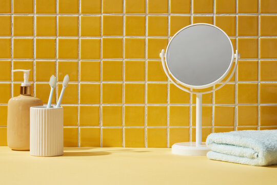 A mirror, towel and toothbrushes inside a bathroom background. Front view. Empty space for display cosmetic products