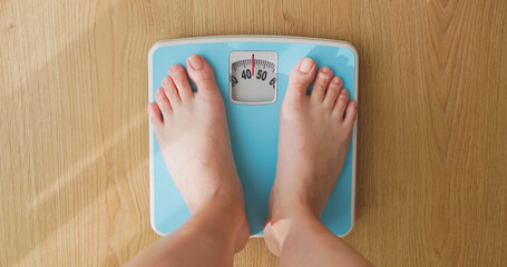 woman measure weight on scale