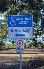 Wheelchair access fishing float and no glass containers signs o a post at Lake Miramar in San Diego, Ca.