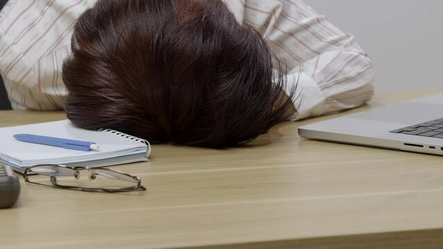 Woman with narcolepsy is fall asleep on office desk..Narcolepsy is a sleep disorder that makes people very drowsy during the day.