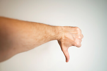 Man showing thumbs down on grey background 