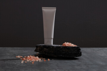 Front view of pink salt and cosmetic decorated in black background
