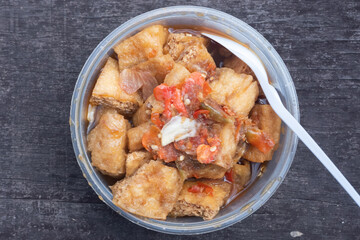 tahu gejrot is fried tofu and mixed with a spicy sauce made from palm sugar and chopped chilies, this food originates from Indonesia