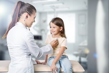 Happy doctor checking child at the clinic.