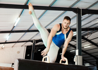 Sports, gymnastics and man training on a beam for balance, flexibility and strength in the gym....