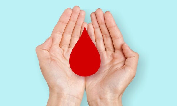 Blood donation concept, Hands holding a red drop of blood