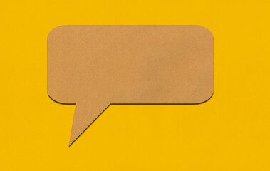 Brown paper speech bubble on yellow paper background.