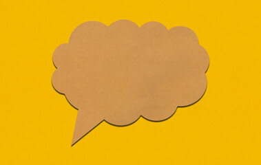 Brown paper speech bubble on yellow paper background.