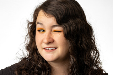 Close up image of pretty young woman winking at the camera on white background