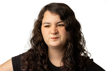 Young woman scrunching her nose, on white background.