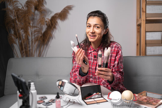 Young hispanic woman professional beauty make up artist vlogger or blogger recording makeup tutorial to share on website or social media recording beauty vlog video live streaming at home.