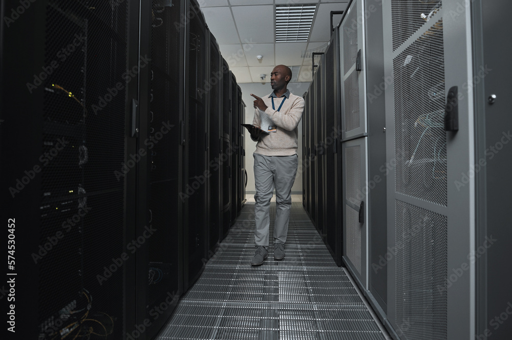 Fototapete Technician, cybersecurity and man in the server room for data maintenance, it or analysis. System, engineer and African male coder or programmer doing inspection on information technology in office.