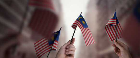 A group of people holding small flags of the Malaysia in their hands