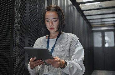 Tablet, server room and security with a programmer asian woman at work on a computer mainframe....