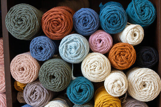 Multicolored cotton balls of yarn and ropes for macrame close up