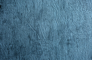 Blue background of decorative plaster with abstract spots. Unusual texture of this wall with beautiful patterns, creative surface background. Finishing coating for building cladding.
