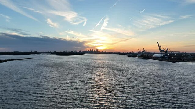 Aerial View Flying over Delaware River Towards Sunset over City of Philadelphia 