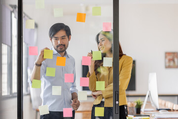 Team of Business female employee with many conflicting priorities arranging sticky notes commenting...