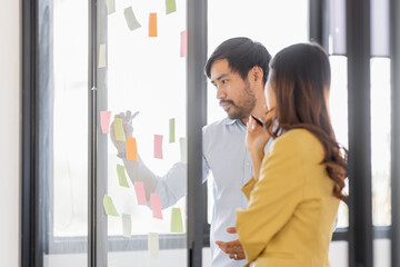 Team of Business female employee with many conflicting priorities arranging sticky notes commenting...