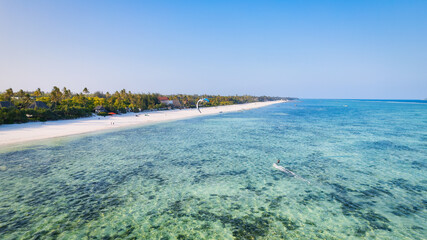 Fototapeta na wymiar This aerial photo of Kiwengwa Beach in Zanzibar showcases the stunning natural beauty of the island, with its golden sand, turquoise waters, and lush foliage creating the perfect backdrop for a relaxi