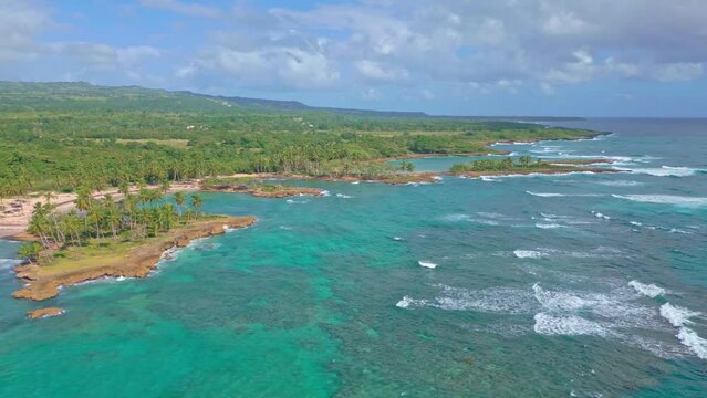 Aerial view of tropical coastline with Playa Los Coquitos during sunny day in Dominican Republic