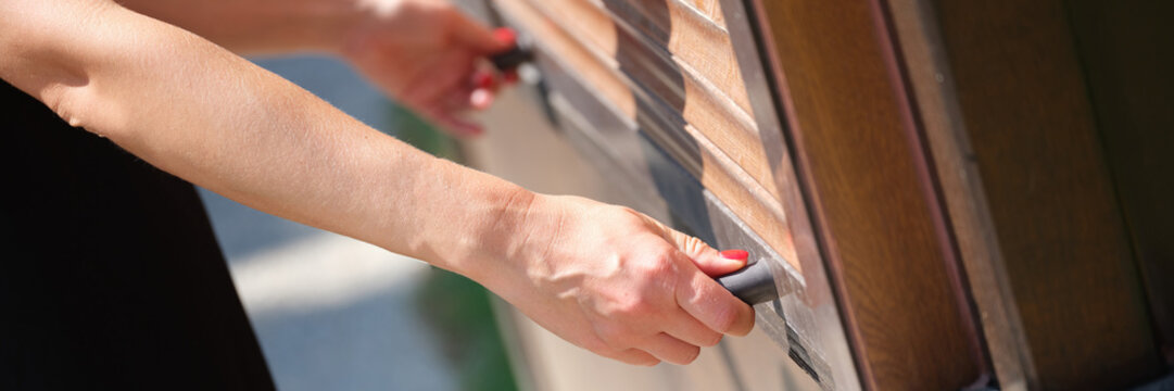 Women hands open outdoor wooden blinds closeup