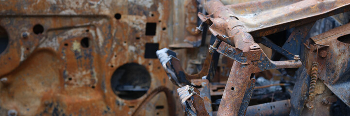 Burnt rusty abandoned car in parking lot