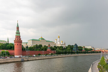 Obraz premium View of Kremlin with Vodovzvodnaya tower, Grand Kremlin Palace from repaired Bolshoy Kamenny Bridge in Moscow city on sunny summer day. Cruise ship sails on the Moscow river