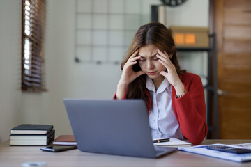 Tired young asian business woman with headache at office, feeling sick at work