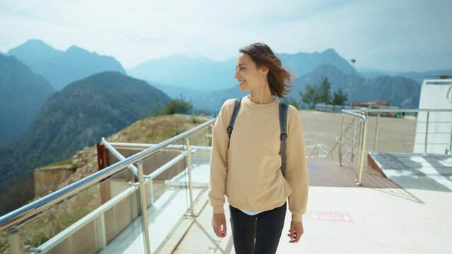 treking camera shot traveler freedom woman with backpack walking at view point on mountain top and enjoying mountains view, summer journey vacation. upper station of cable way in Antalya, Turkey