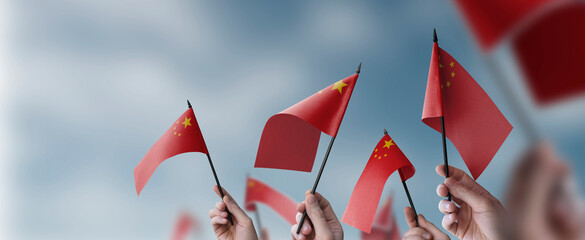 A group of people holding small flags of the China in their hands