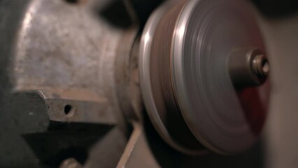 A sharpened abrasive disc rotates on a grinder close-up. Stopping the grinding machine