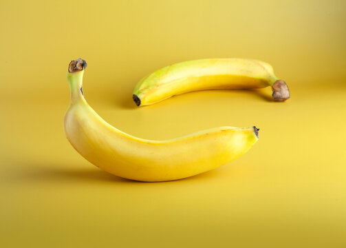 two bananas on yellow background