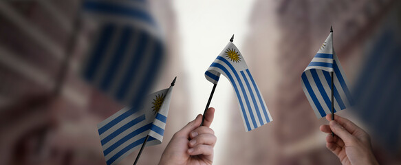 A group of people holding small flags of the Uruguay in their hands