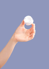 Skincare, hands and cream container in studio isolated on a purple background for hydration. Cosmetics, dermatology and woman or female model with lotion, creme or moisturizer for beauty aesthetics.