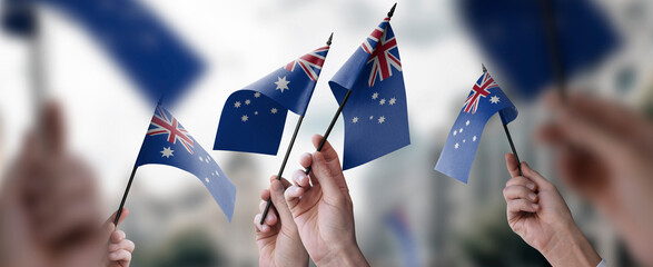 A group of people holding small flags of the Australia in their hands