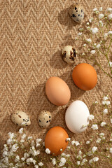 Elegant Easter greeting card design, natural color eggs and flowers on warm beige rug background, copy space