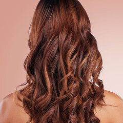 Naklejka premium Beauty, back and hair care of woman in studio isolated on a red background for haircare. Curly hairstyle, keratin cosmetics and female model with salon treatment for growth, texture and balayage.