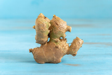 Ginger root on blue wooden background.