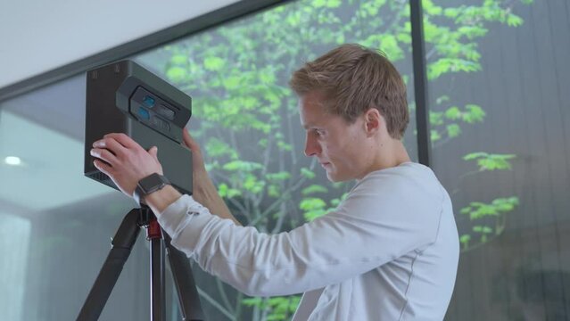 Male floor plan technician fits matterport device to tripod masterfully.