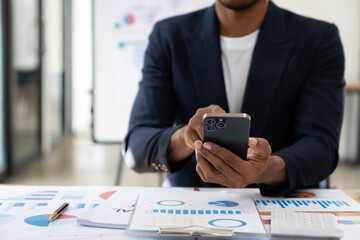 Asian male businessman is using mobile phone to communicate in finance, management, investment of...
