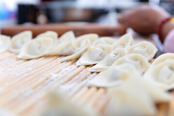 Neatly wrapped wontons are arranged on a dinner plate