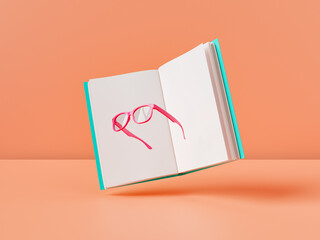 Opened textbook with pink eyeglasses against bright orange background