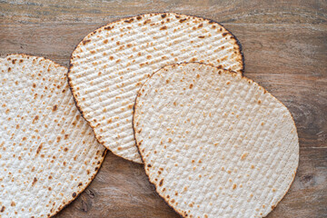 Matzah for Jewish holiday Pesach on wooden background.