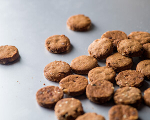 Round homemade cookies scattered on a light gray background.