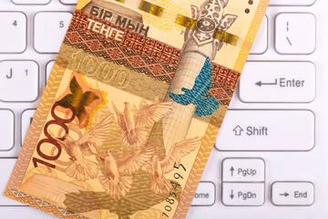 Banknote in denomination of 1000 Kazakhstani tenge on a computer keyboard