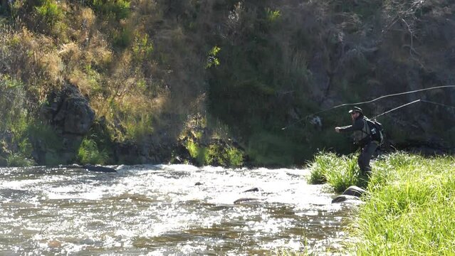 a slow motion clip of an angler casting a fly while fishing the ecumbene river at kosciuszko national park in nsw, australia