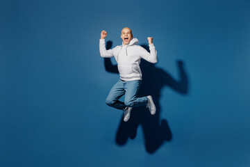 Fototapeta na wymiar Full body overjoyed happy exultant fun young dyed blond man of African American ethnicity in white hoody jump high do winner gesture isolated on plain dark royal navy blue background studio portrait