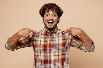 Surprised happy fun cheerful cool Indian man wear brown shirt casual clothes point index fingers on himself isolated on plain pastel light beige background studio portrait. People lifestyle concept.