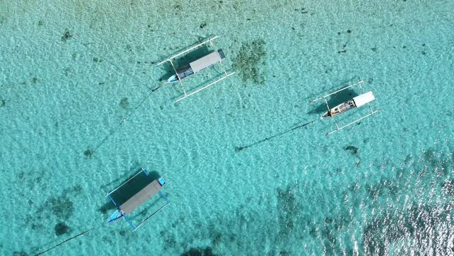 Boats on anker in blue clear ocean on paradise island. Aerial view.